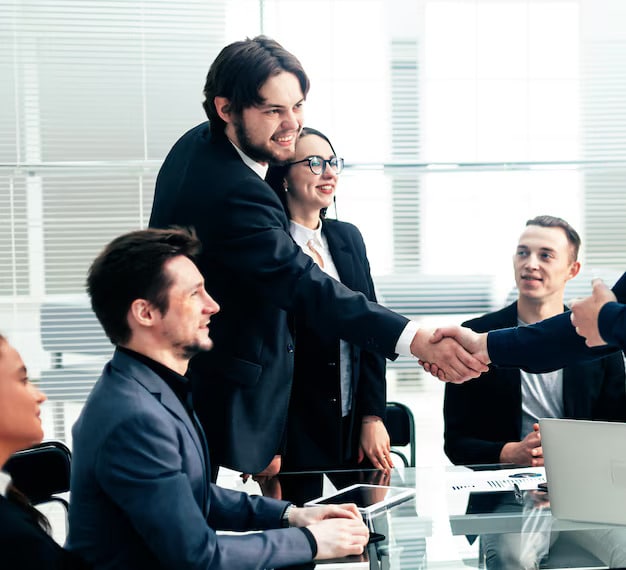 Group of businessmen smiling and shaking hands, satisfied with AFB mortgage services and celebrating their successful business loan approval.