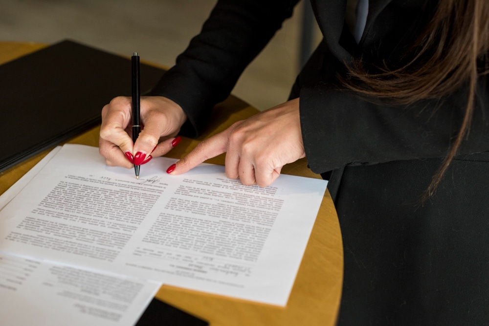 A woman signing loan documents with AFB.